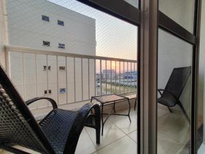 einen Balkon mit Stühlen und einem Tisch auf dem Balkon in der Unterkunft Apartamento centro de São Pedro da aldeia ao lado do comércio e a 500 metros da orla da lagoa in São Pedro da Aldeia