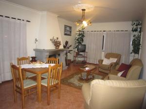 a living room with a table and chairs and a fireplace at Residencial Mira-Sol in Seia