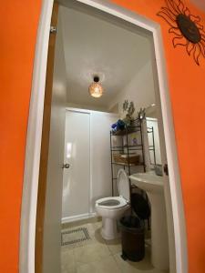 La salle de bains orange est pourvue de toilettes et d'un lavabo. dans l'établissement Apartamento En Fraccionamiento Privado 6 Personas, 5 Camas, Piscina cerca de la Playa, à Playa del Carmen