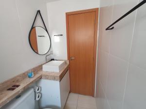 ein Badezimmer mit Waschbecken und Spiegel in der Unterkunft Apartamento centro de São Pedro da aldeia ao lado do comércio e a 500 metros da orla da lagoa in São Pedro da Aldeia + 25 Fotos