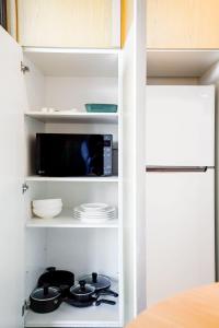 a kitchen with a stove and a microwave at Marina Tower - Stunning Harbour & City View in Melbourne +12 photos