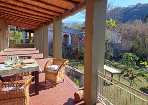 a patio with a table and chairs on a balcony at Casa de Campo Kanan in San Miguel de Tucumán