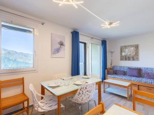een woonkamer met een tafel, stoelen en een bank bij Appartement chaleureux pour 8 personnes proche des pistes - FR-1-695-59 in Gouaux-de-Larboust