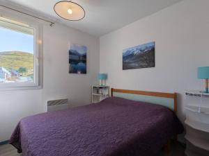 een slaapkamer met een paars bed en een raam bij Appartement chaleureux pour 8 personnes proche des pistes - FR-1-695-59 in Gouaux-de-Larboust