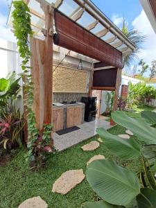 a patio with an outdoor grill in a yard at Otila Bali Villa in Uluwatu