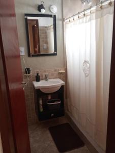 a bathroom with a sink and a shower with a mirror at Departamento a 150 metros de la catedral con cochera in San Fernando del Valle de Catamarca