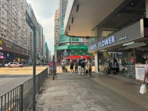 香港可爱小家 油麻地 弥敦道 正大街 地铁口1分钟 两房一厅一卫有厨房 4床可住4-5人的一群人走在城里的人行道上