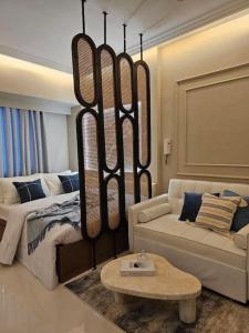 セブシティにある200mbps WiFi, Luxury condo near Ayalaのベッドとソファのあるリビングルーム