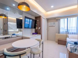 セブシティにある200mbps WiFi, Luxury condo near Ayalaのテーブルとリビングルームが備わります。