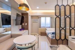 セブシティにある200mbps WiFi, Luxury condo near Ayalaのベッド、ソファ、テーブルが備わる小さな客室です。