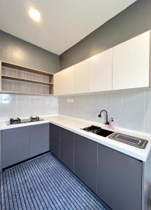 a kitchen with white cabinets and a sink at AbelHome in Teluk Intan