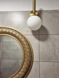 a bathroom with a mirror and aendant light at Few Steps to the Bay in Jūrmala +32 photos