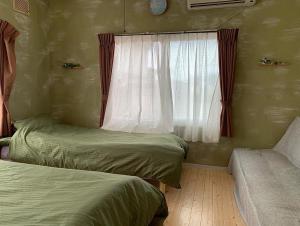 a bedroom with two twin beds and a window at Cozy Penguin House Bibai in Bibai