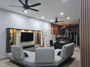 a living room with a couch and a flat screen tv at Shervio Home Bentong in Bentong