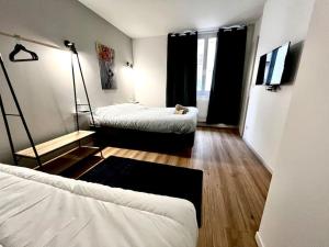 a room with two beds and a cat laying on the floor at Le LEGO, 3 chambres, 8 personnes et parking, centre in Grenoble