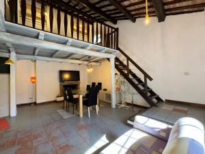 a living room with a staircase and a table with chairs at Casa Matilde in Bassano in Teverina