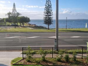 an empty street next to the ocean with a pole at Beach View Cottage in Clontarf