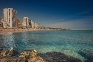 a beach with buildings and people in the water at Estudios RH Vinaros in Vinarós
