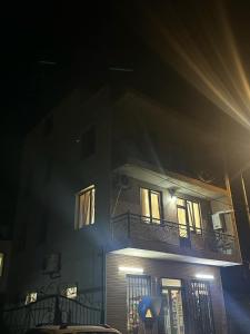 Un edificio alto con un balcón por la noche. en Квартира, en Minda