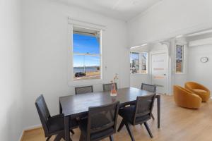 a dining room with a table and chairs and a window at Beach View Cottage in Clontarf