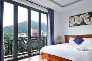 a bedroom with a bed and a large window at Kim Ngân Hotel in Con Dao