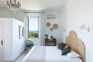 a white bedroom with a bed and a window at La Solenzara hôtel - 3 Etoiles Supérieur - Appartement & SPA in Sari Solenzara +63 photos