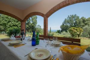 una mesa con copas y botellas de vino encima en Daller Bianca Apartment by Wonderful Italy, en Soiano del Lago