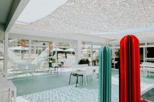 two surfboards standing in the middle of a swimming pool at Hôtel Saint-Clair, côté Plage in La Grande Motte