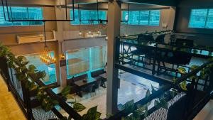an overhead view of a pool in a building with plants at Friends Station Tukkom Hostel & Cafe in Pattaya South