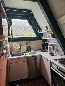 eine kleine Küche mit Spüle und Fenster in der Unterkunft Ferienhaus 196 in Fedderwardersiel in Fedderwardersiel