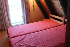ein Bett in einem Zimmer mit Fenster in der Unterkunft Ferienhaus 196 in Fedderwardersiel in Fedderwardersiel