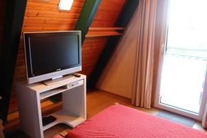 einen Fernseher auf einem Stand in einem Zimmer mit Fenster in der Unterkunft Ferienhaus 196 in Fedderwardersiel in Fedderwardersiel + 6 Fotos