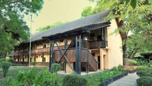 a building with a thatched roof and a balcony at Cresta Riley's Hotel in Maun