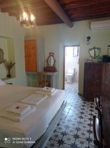 a bedroom with a bed and a bathroom at MYRTIA , Traditional Kimolos house in Kimolos