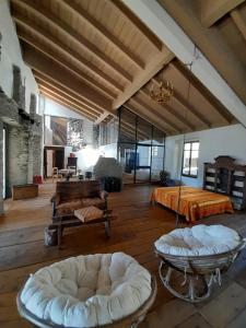 une grande chambre avec un lit et deux poufs dans l'établissement B&B Cantine Marchesi, à San Bernardo