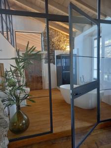 une salle de bain avec une grande porte vitrée avec un vase dans l'établissement B&B Cantine Marchesi, à San Bernardo
