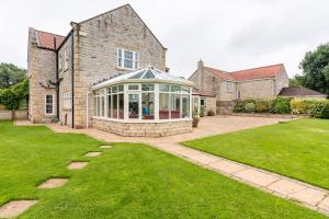 an external view of a house with a conservatory at Millfield Cottage in York