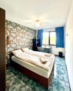 ソフィアにあるThe Green Apartment 2BR - free parkingの青いカーテンが備わるベッドルーム1室です。