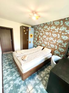 ソフィアにあるThe Green Apartment 2BR - free parkingの花柄の壁紙が貼られたベッドのある寝室