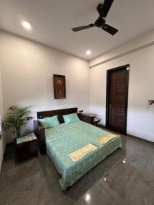 une chambre avec un lit et un ventilateur de plafond dans l'établissement Lumbs', à Jaipur
