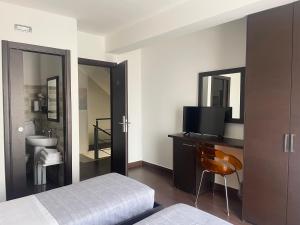 a bedroom with a bed and a tv and a bathroom at Nacional B&B in Monforte San Giorgio Marina