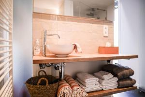 a bathroom with a sink and towels on a shelf at Finca Feliz with private jacuzzi & sauna in Oostkamp +55 photos