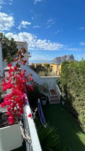 a balcony with red flowers and stairs on a building at Espectacular villa junto a la playa, piscina privada y vistas al mar in Calpe