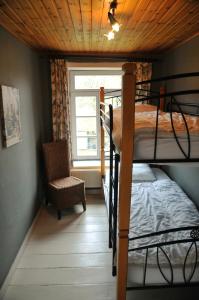 a bedroom with two bunk beds and a chair at Le Presbytère in Soy