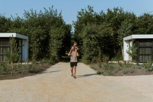 a man walking down a gravel road carrying a child at MarinaPark Residentie Bloemendaal in Vogelenzang