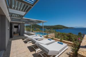 帕诺尔莫斯斯科派洛斯Adrina Grand Hotel的连排躺椅和一个游泳池