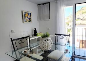 Una mesa de cristal y sillas en una habitación con ventana. en Casa del Castillo, en Cazorla