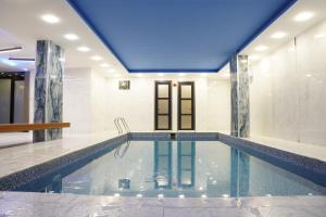 a pool in a house with a blue ceiling at Ward Hotel Basra in Al Başrah