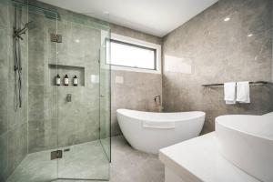 a bathroom with a tub and a glass shower at Family Fairyland 4 BRM 3 BATH near Chadstone SC in Oakleigh East +23 photos