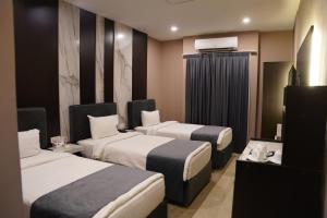une chambre d'hôtel avec deux lits et une télévision dans l'établissement Ward Hotel Basra, à Bassorah